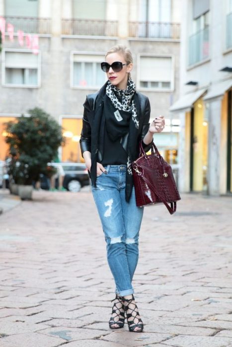 Chica usando jeans blazer negro, bufanda y bolso morado 