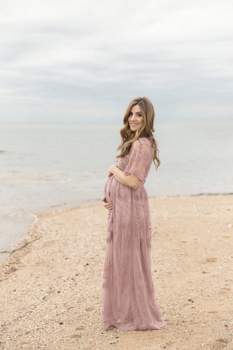 Vestidos para baby shower, mujer embarazada en sesión fotográfica de maternidad en la playa al aire libre, con vestido rosa pálido con encaje y tela de tul