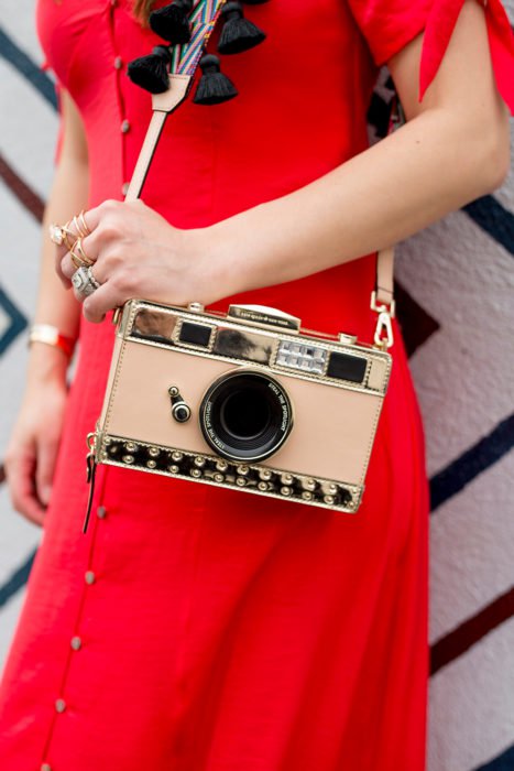 Chica con un bolso en forma de cámara fotográfica 