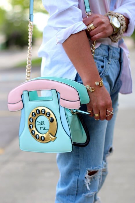 Chica con una bolsa en forma de teléfono de disco 