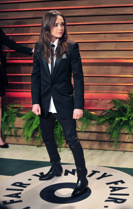 Famosas con traje; Ellen Page con saco y pantalón negro con camisa blanca y corbata, cabello largo y suelto