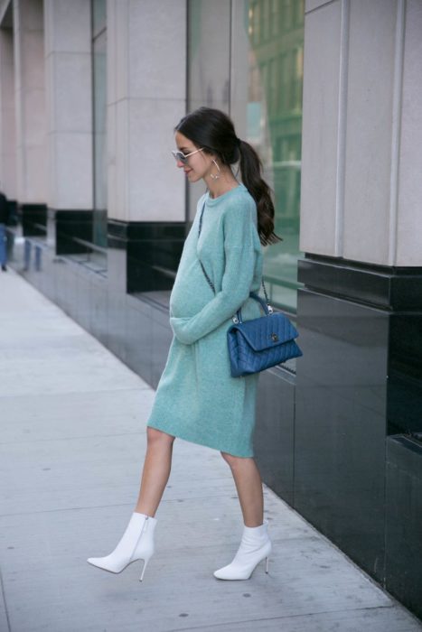 Chica usando un vestido largo color azul marino mientras está parada en la calle recibiendo una sesión de fotos 